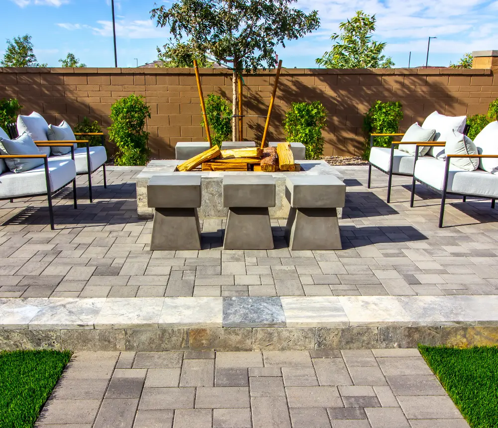 A large paver patio with outdoor furniture and a fireplace