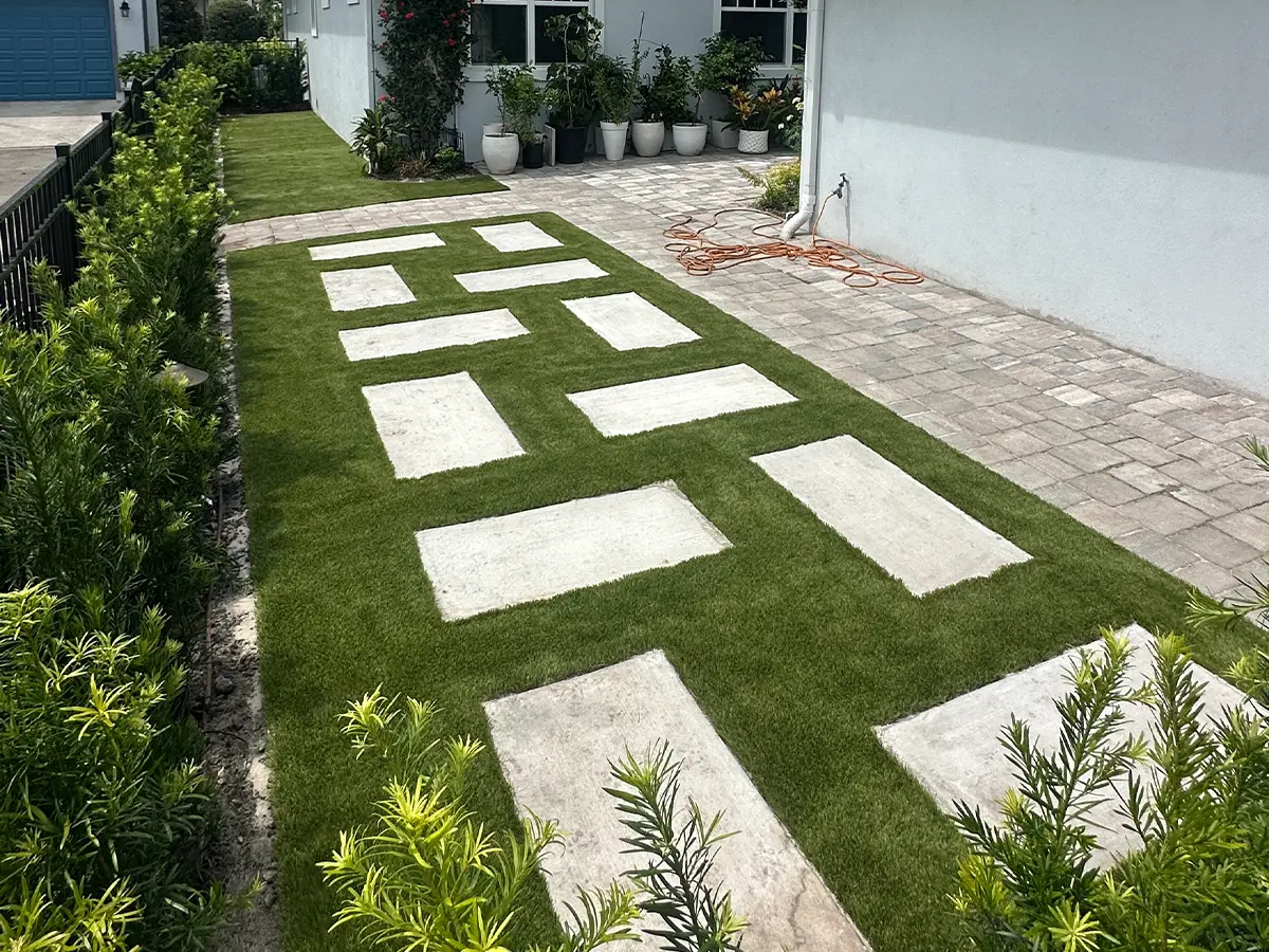 Modern turf design with concrete pavers in a residential yard, showcasing sleek landscaping.