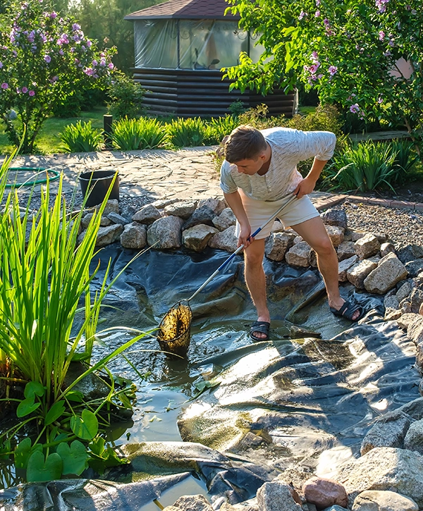 A worker doing pond cleaning services in Sanford FL