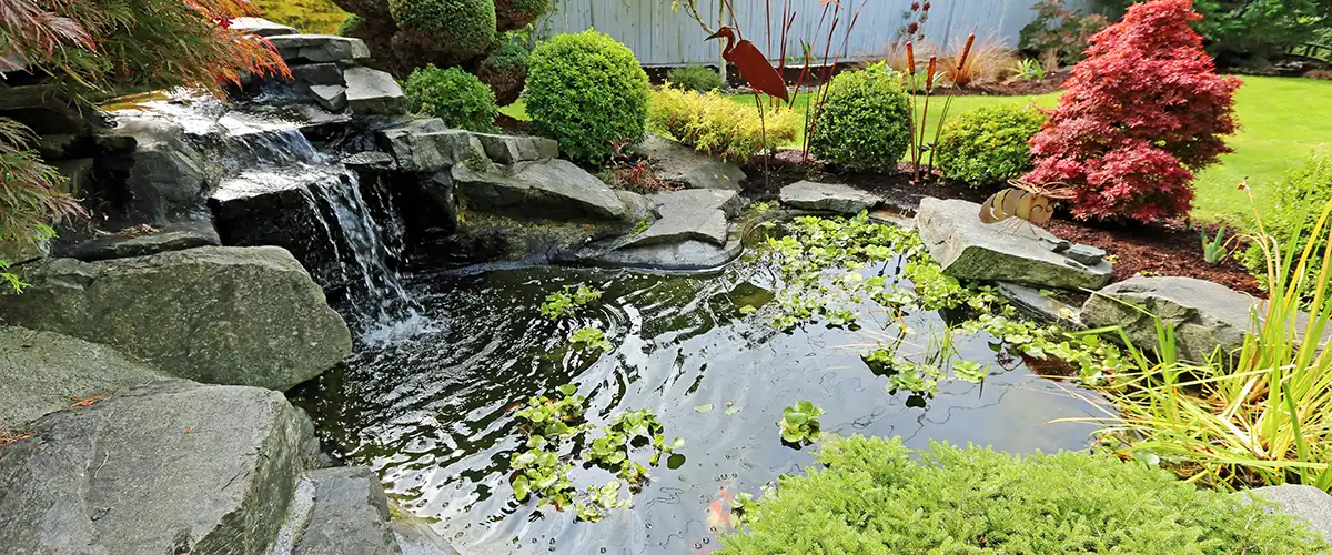 Pond with cascading waterfall and landscaping
