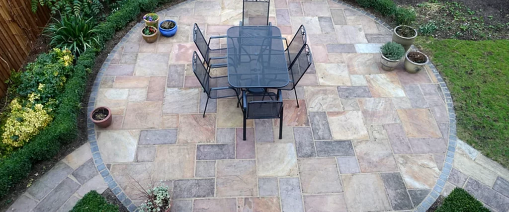 paver patio florida patio installation circular stone patio with black metal furniture surrounded by lush greenery
